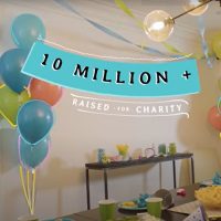 10 Million raised for Charity - in the background a table set for a birthday party with balloons.