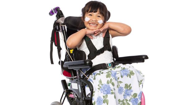 Stephanie smiles brightly with her hands tucked under her chin