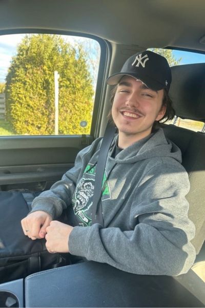 Image of Sebastian in a car he is a scholarship recipient 