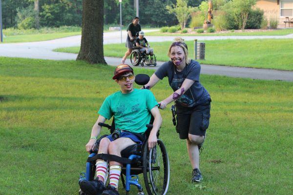 Kalin being pushed on grass in a wheel chair