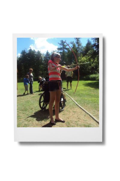 Image of Morgan Shooting bow and arrow at camp Easter Seals 