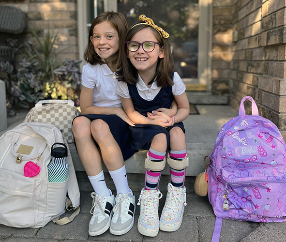 Everly on her front steps with her sister before school.
