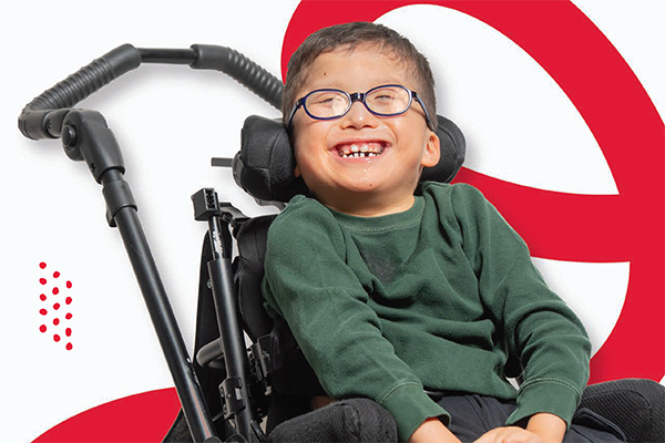 A boy smiles from his wheelchair.
